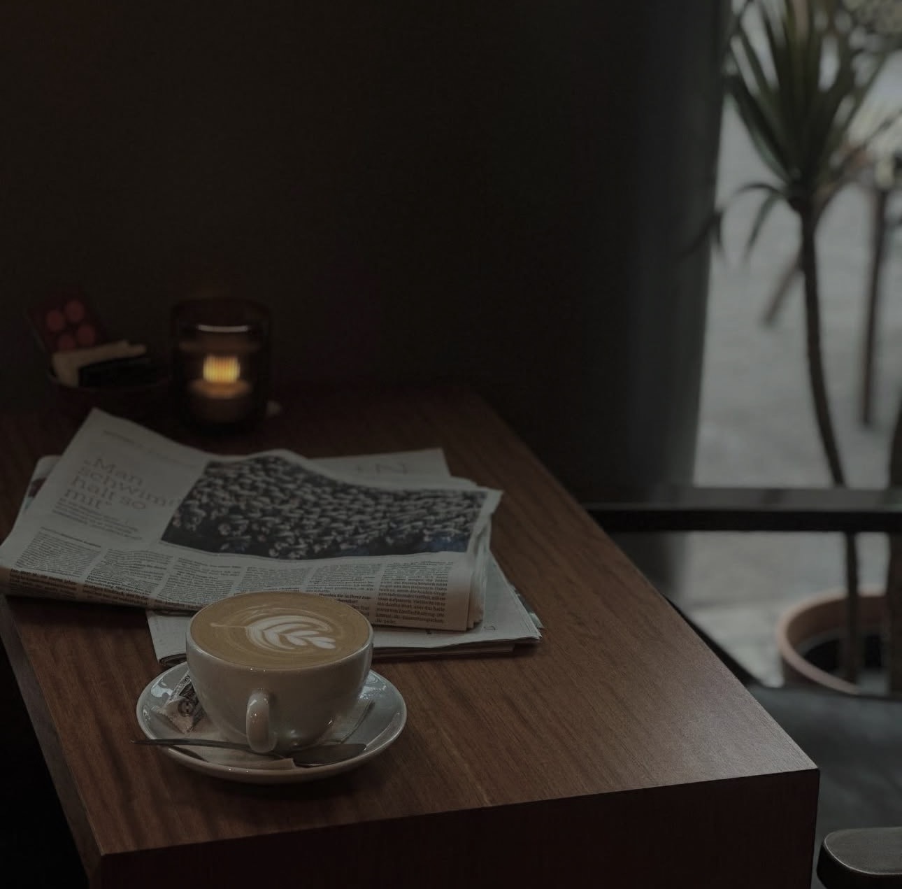 Cappuccino und Zeitung am Fensterplatz