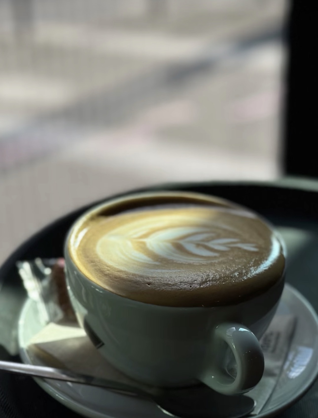 Cappuccino mit Latte Art am Fenster